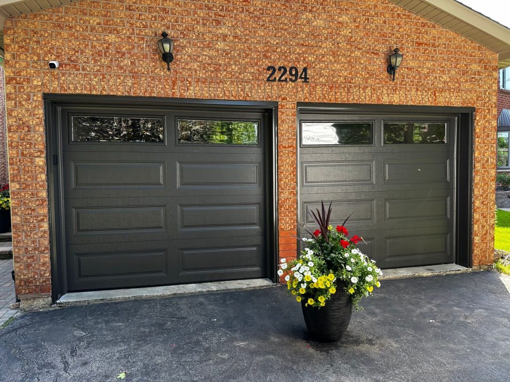 Modern garage door with frosted windows installed on a brick home