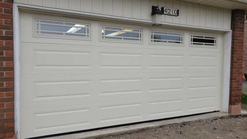 White double-car garage door with windows installed in Milton by Pro Entry